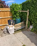 Before: rubbish and a broken planter by a garden gate