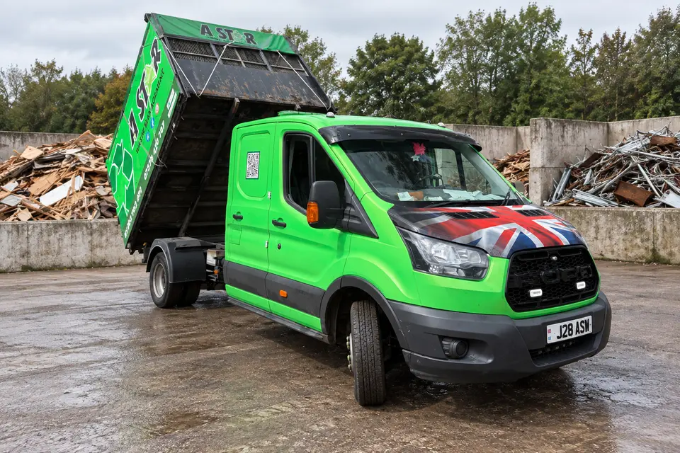 A Star tipper van with its body raised while unloading at a waste recycling yard